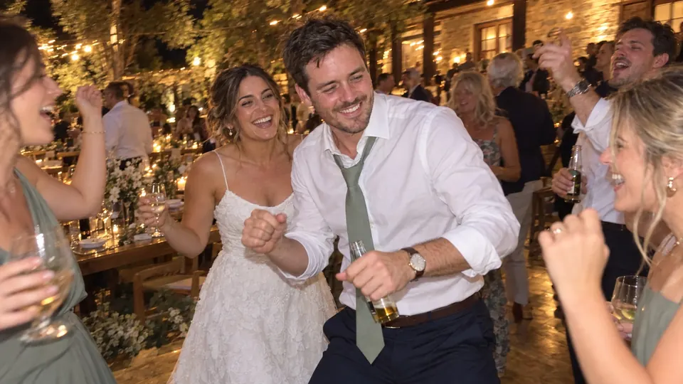 The groom dancing with friends late in the night.
